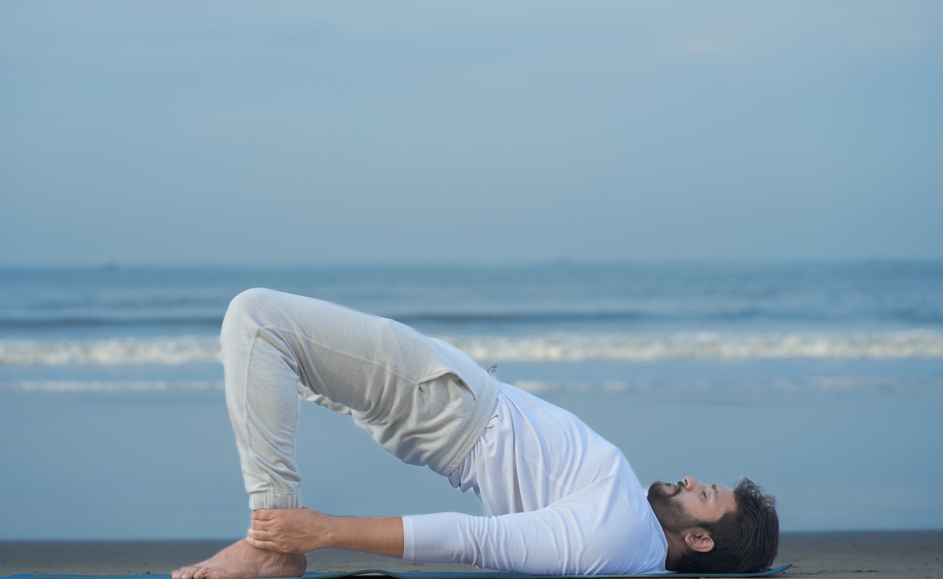 Bridge pose practice by the sea