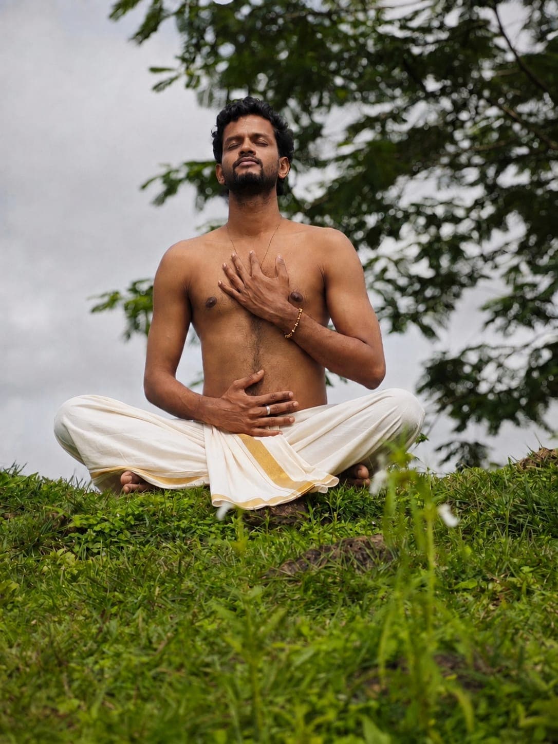 Meditation practitioner seated outdoors in quiet reflection
