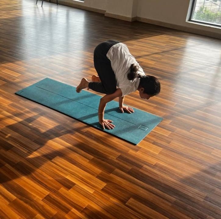 Yoga practitioner balancing on hands indoors on a mat