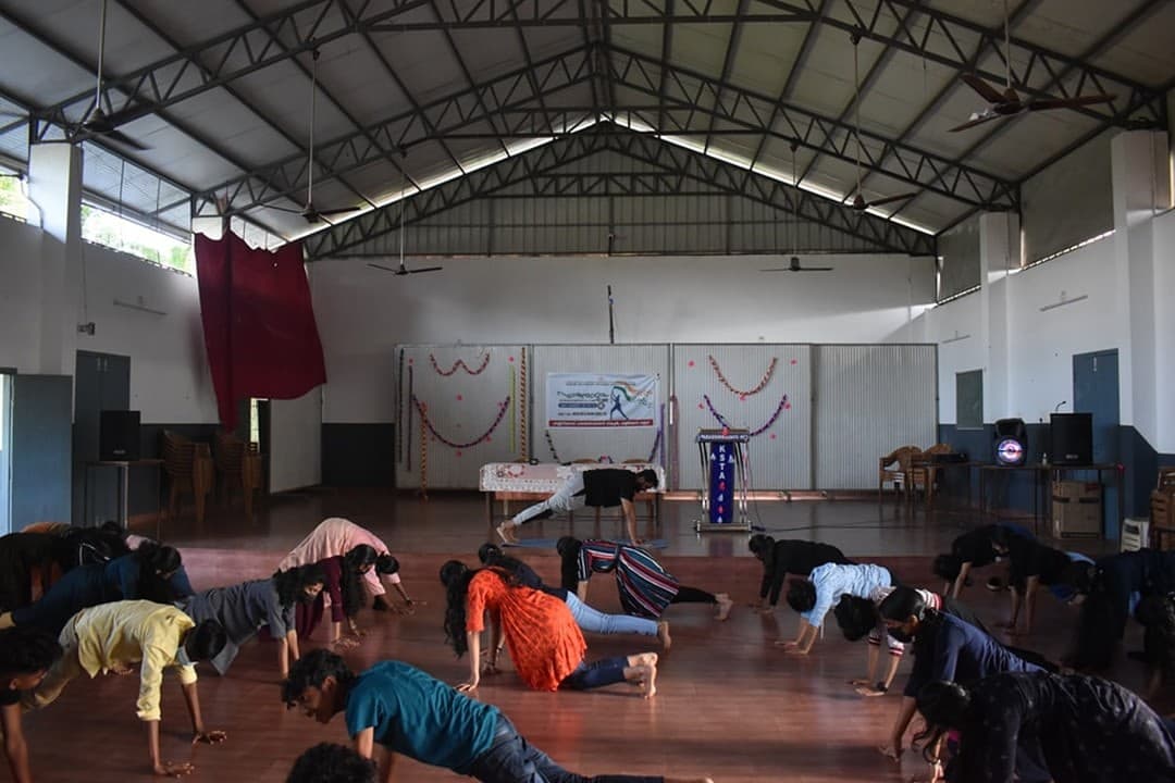 Students following a guided movement practice in a hall